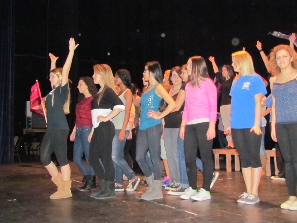 Layne Mossop, who plays Elle Woods in the production of Legally Blonde: The Musical, raises her arms while the remainder of the cast holds their pose for instructor Dawn Baldwin during a rehearsal of the dance number What You Want on Friday, January 31.