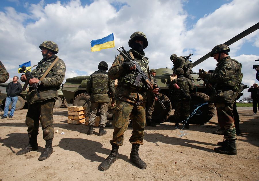 Ukrainian+army+troops+receive+ammunition%2C+with+a+Ukrainian+flag+in+the+back%2C+in+a+field+on+the+outskirts+of+Izyum%2C+Eastern+Ukraine%2C+Tuesday%2C+April+15%2C+2014.+An+Associated+Press+reporter+saw+at+least+14+armored+personnel+carriers+with+Ukrainian+flags%2C+one+helicopter+and+military+trucks+parked+40+kilometers+%2824+miles%29+north+of+the+city+on+Tuesday.+%28AP+Photo%2FSergei+Grits%29